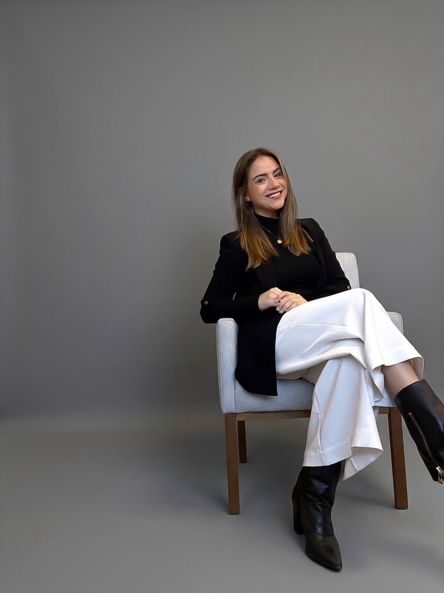 Camila Gradowski Montanari sentada em uma poltrona no estúdio